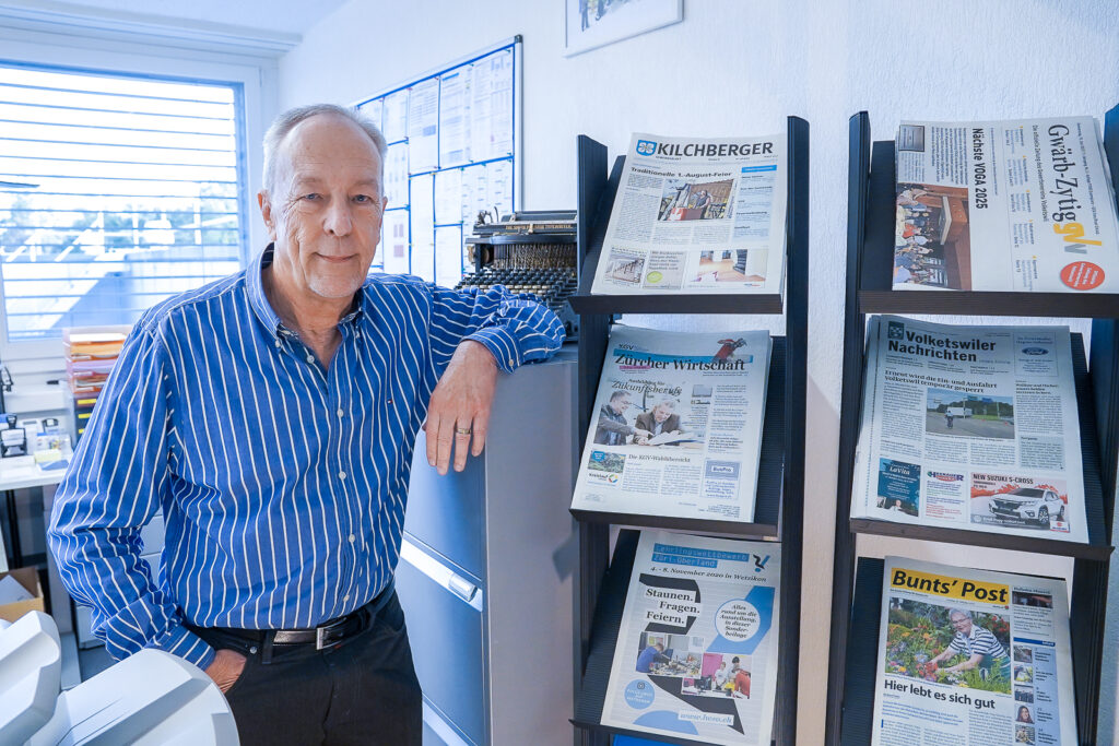 Samuel Bachmann, der Gründer von Bachmann Printservices, steht neben einer Ausstellung von Referenzdrucken im Unternehmen in Volketswil.